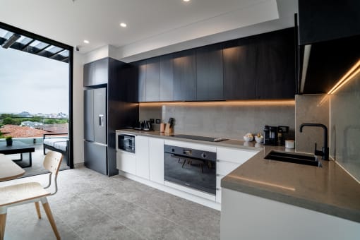 a kitchen with black and white cabinets and a large window