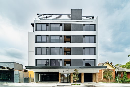 the condo building has a facade of black and white asymmetrical glass windows and a