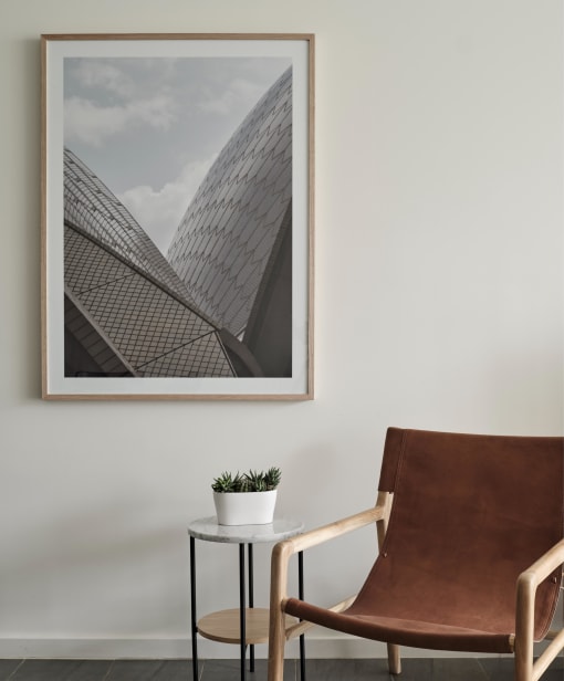 a picture frame hanging on a wall with a chair and a table