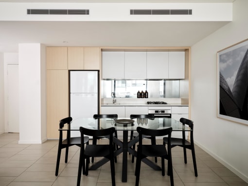 a kitchen and dining room with a glass table and black chairs