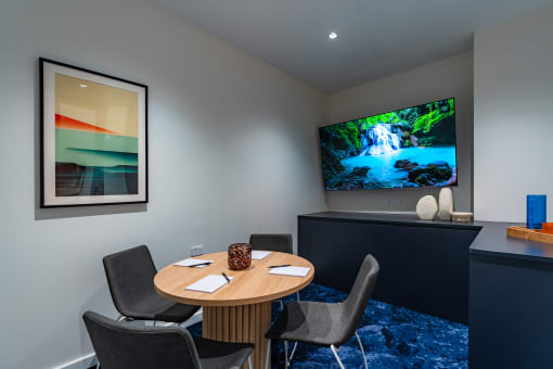 a conference room with a table and a tv on the wall