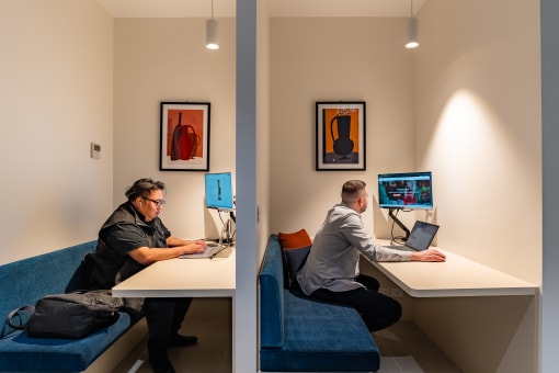 two men sitting at their computers in a room