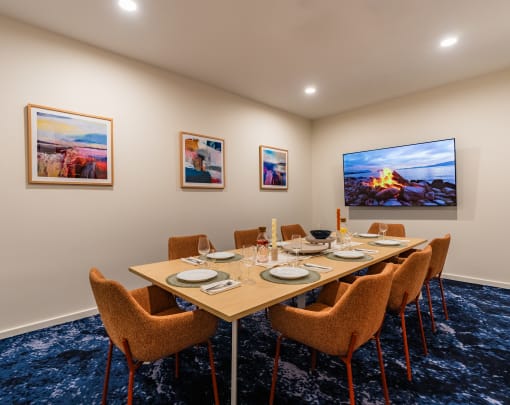 a dining room with a table and chairs and paintings on the wall