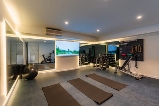 a gym with yoga mats and a tv on the wall