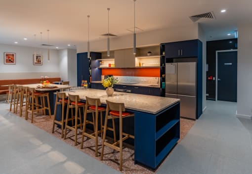 a large kitchen with a long island with chairs and a counter