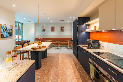 the kitchen and dining room of a modern house with black cabinets and a counter top