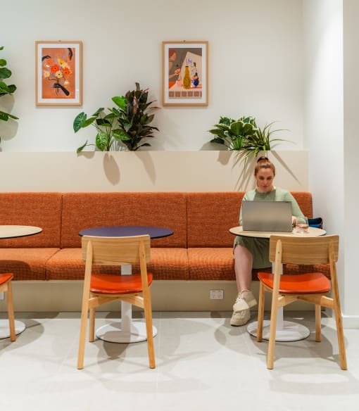 a woman sitting at a table with a laptop