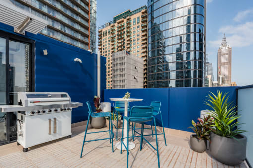 a terrace with a table and chairs and a barbecue grill