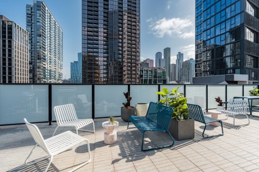 a roof deck with chairs and a view of the city