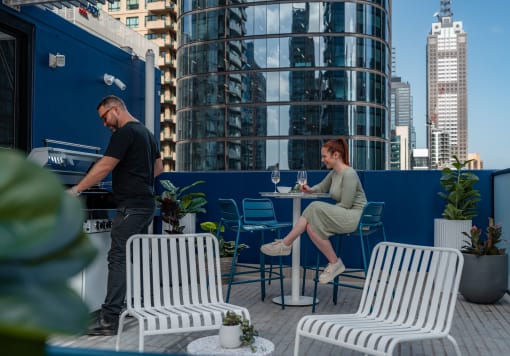 a man and a woman sitting at a table on a rooftop patio