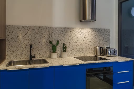 a kitchen with blue cabinets and a counter top and a sink