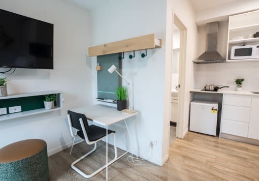 a small desk with a chair in a room with a kitchen