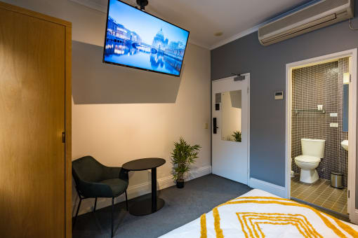 a hotel room with a bed and a tv on the wall