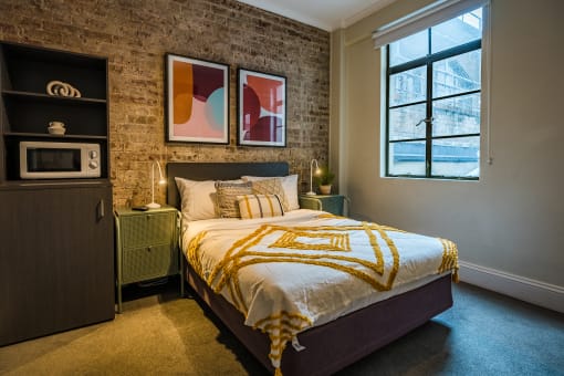 a bedroom with a bed and a exposed brick wall