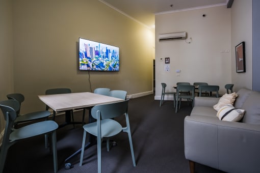 a seating area with a table and chairs and a tv