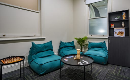 a living room with turquoise chairs and a table with chess pieces