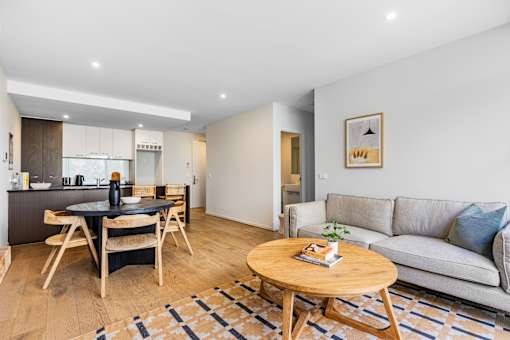 A modern living room with a grey sofa and a wooden coffee table.