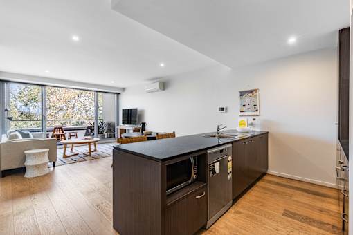 A modern kitchen with dark wood cabinets and a large island.