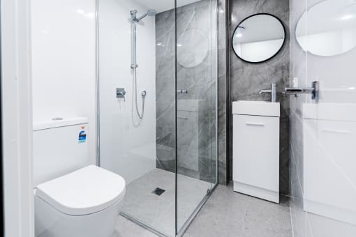 a white bathroom with a shower and a toilet