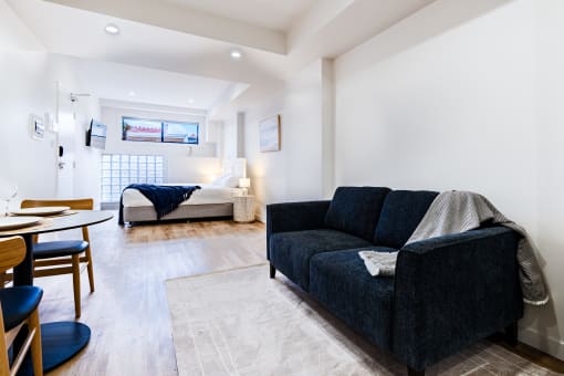 a living room with a couch and a table and a bed