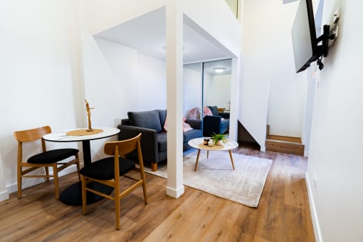 a living room with a small table and a couch and a mirror