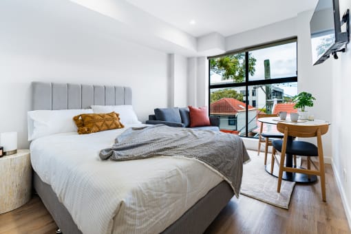 a bedroom with a bed and a large window