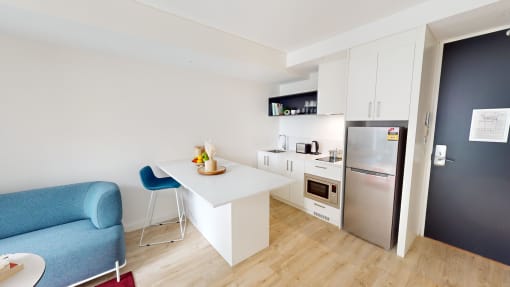 a living room with a kitchen and a blue couch