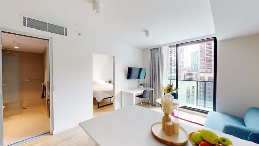 a living room with a white table and a door to a bedroom