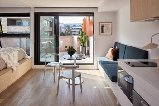 a living room with a couch and a table and a balcony