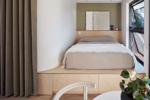 a bedroom with a bed and a table and a window