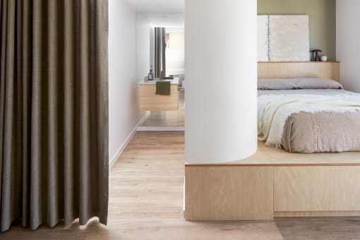 a bedroom with a bed and a white column in front of it
