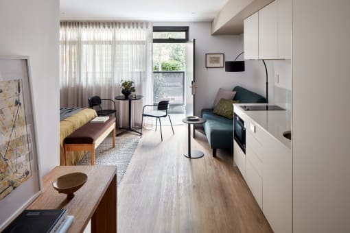 a studio apartment with a kitchen and living room