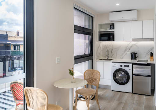 a living room with a table and chairs and a washing machine