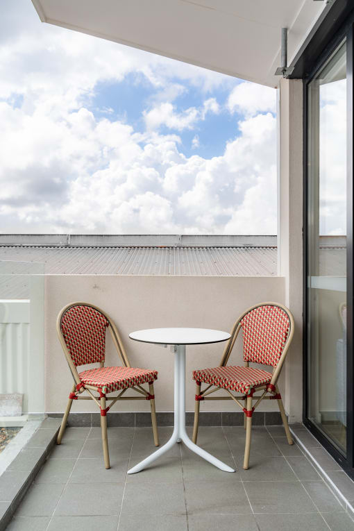 a patio with two chairs and a table on a balcony