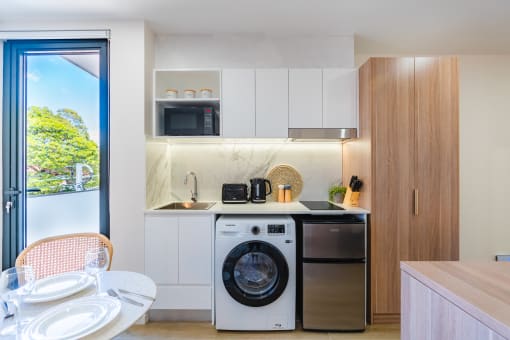 a kitchen and dining area with a washing machine and a dishwasher