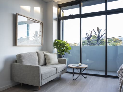 a living room with a couch and a table in front of a window