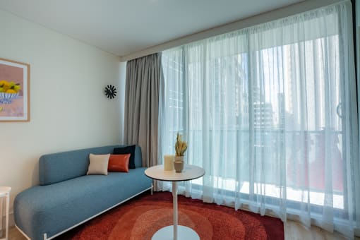 a living room with a blue couch and white curtains