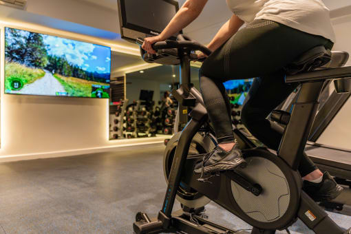 a woman riding an exercise bike in a gym