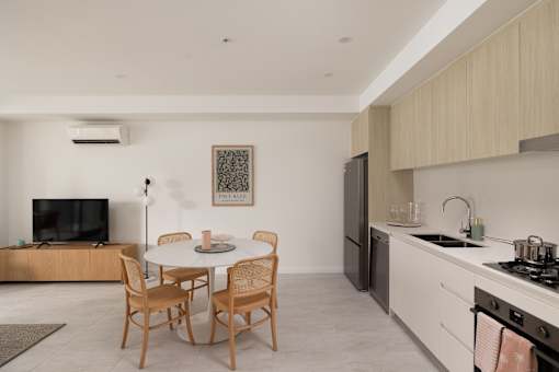 A modern kitchen with a dining table and chairs.
