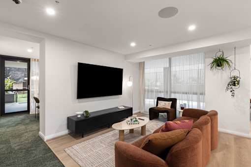 A living room with a flat screen TV mounted on the wall.