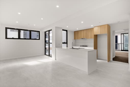 A modern kitchen with a white countertop and wooden accents.