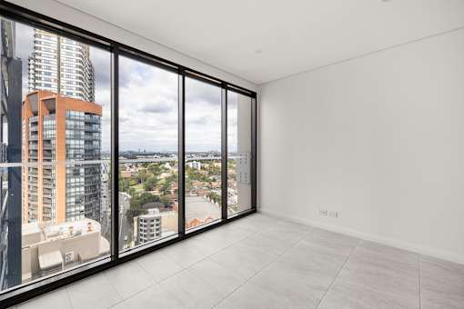 A large empty room with a view of the cityscape outside.