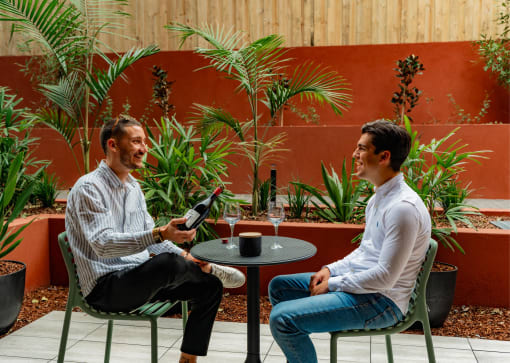 two men sitting at a table in a patio