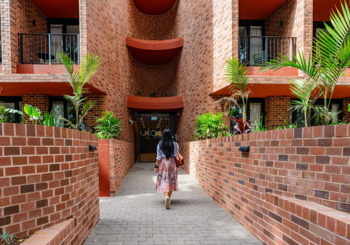 a woman walking down a corridor in front of a building