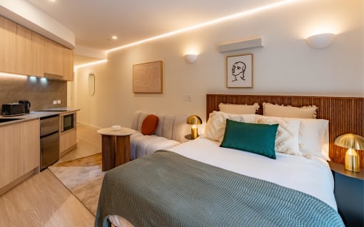 a bedroom with a bed and a kitchen