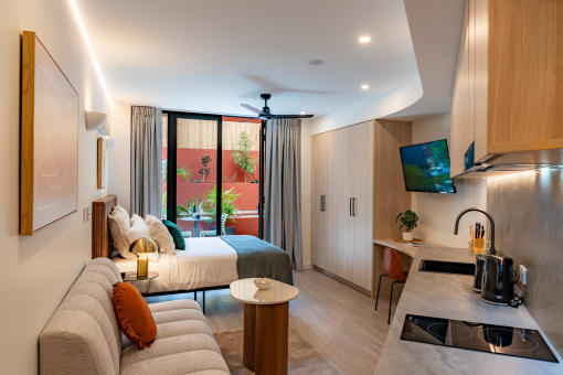 a hotel room with a bed and a living room and a kitchen