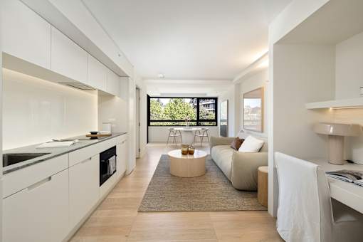 A modern kitchen with white cabinets and a large island.