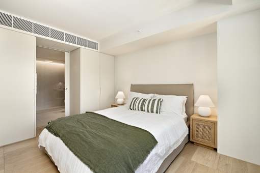 A bedroom with a bed, nightstand, and lamp.