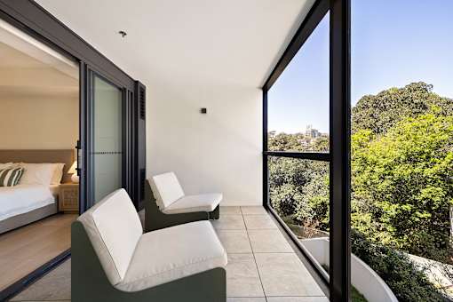 A bedroom with a view of the trees outside the window.