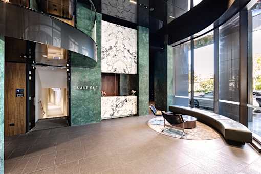 A modern interior with a green marble wall and a wooden door.